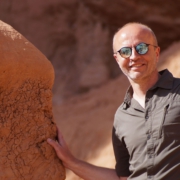 Foto von Roland Streicher mit Sonnenbrille vor einem roten Sandfelsen