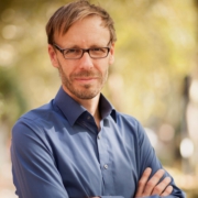 Porträtfoto Christopher End in Hemd vor Bäumen