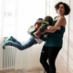 Kiran Deuretzbacher wirbelt ihr Kind umher, das einen Schulranzen trägt