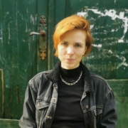 Porträtfoto von Ruth Abraham, in schwarzer Jeansjacke vor einer alten grünen Tür