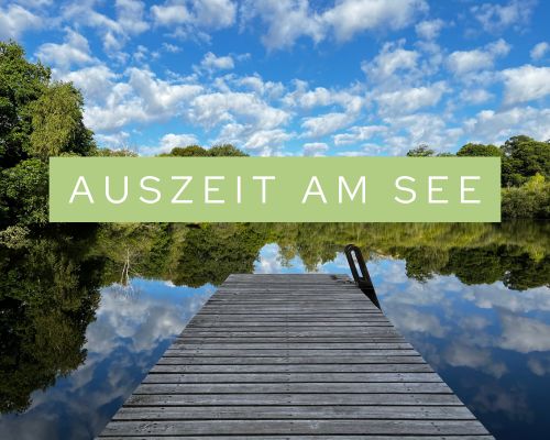 Foto eines spiegelglatten Sees, in dem sich die Wolken spiegeln. Schriftzug. Auszeit am See