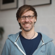 Foto von Christopher End, lächelnd, Innenraum.