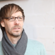 Foto von Christopher End, nachdenklich an der Kamera vorbeischauend