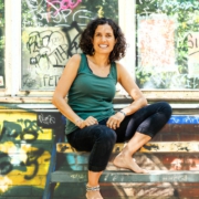 Kiran Deuretzbacher vor einer bunten Wand voller Graffiti